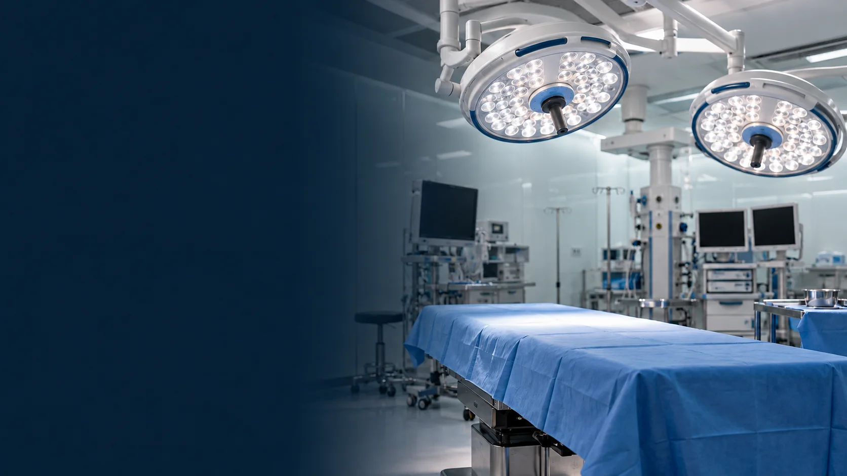 Sala de cirurgia vazia, com a mesa coberta por campo azul e os focos de luz acesos